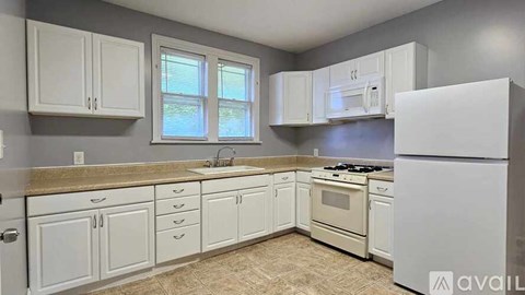 A kitchen with white appliances and cabinets.