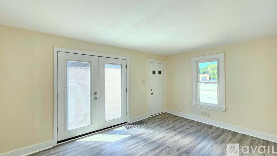 A room with a window, a door, and a wall with a window.