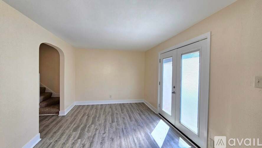 A room with a wooden floor and a sliding glass door.