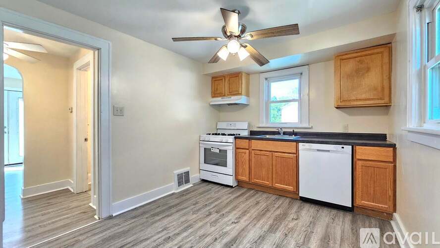 A kitchen with wooden cabinets and a ceiling fan.