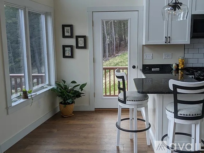 A kitchen with white cabinets and a black countertop.