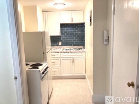 A kitchen with white appliances and cabinets.