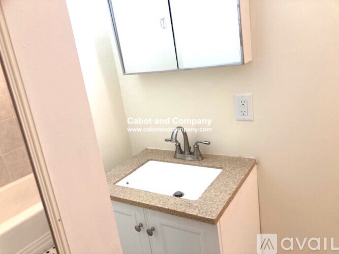 A bathroom with a sink and a white cabinet.