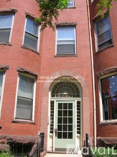 A red brick building with a white door and windows.