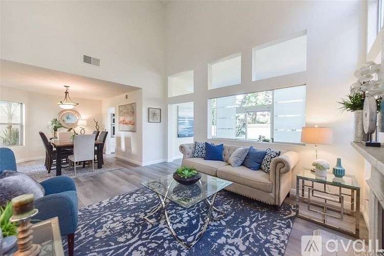 A living room with a couch, chairs, and a dining table.