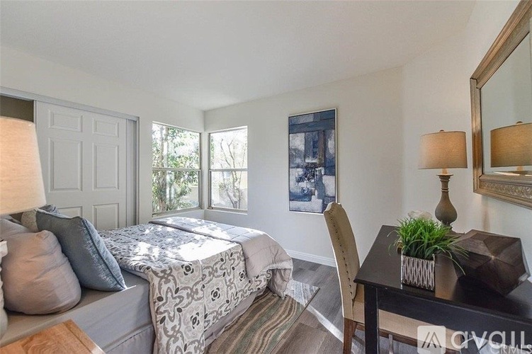 A bedroom with a bed, desk, and chair.