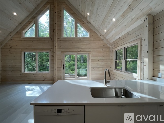 A modern kitchen with wooden walls and a large island.