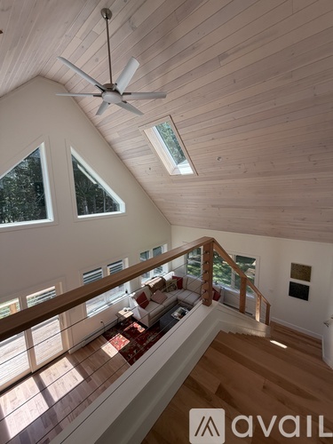A wooden ceiling fan hangs from the ceiling of a spacious room.