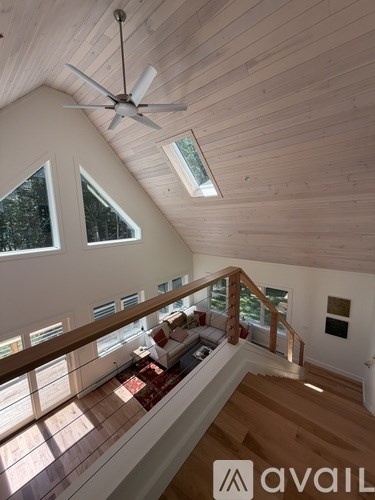 A wooden ceiling fan hangs from the ceiling of a spacious room.