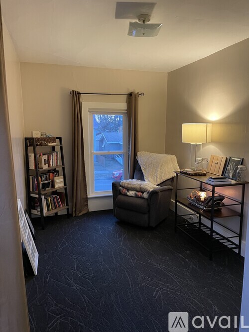 A living room with a grey sofa and a black floor.