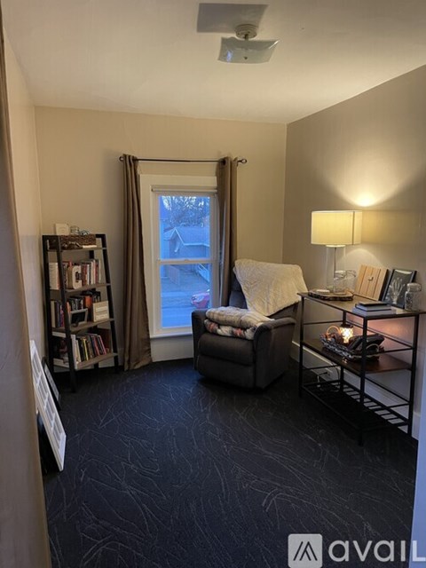 A living room with a grey sofa and a black floor.