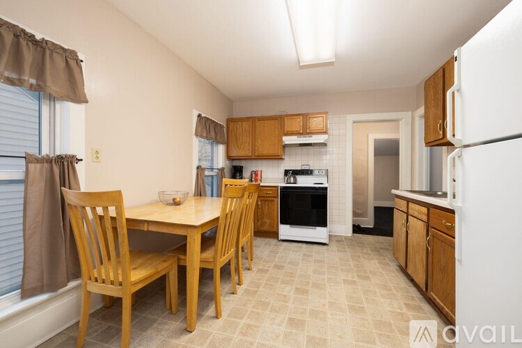 A kitchen with wooden chairs and a table with a bowl on it.