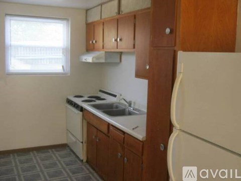 A kitchen with wooden cabinets and a white stove top oven.