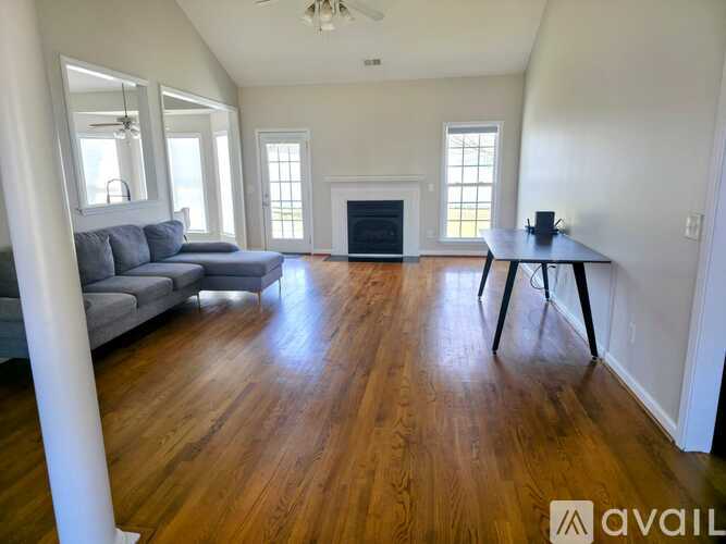 A living room with a grey sofa and a wooden floor.