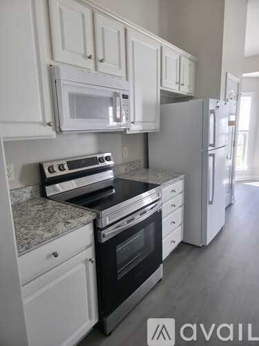 A kitchen with white cabinets and appliances.