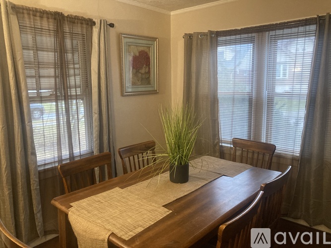 A dining room with a wooden table and chairs.