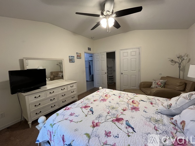 A bedroom with a large bed and a flat screen TV.