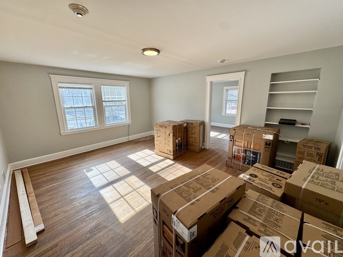 A room with boxes on the floor and shelves on the wall.