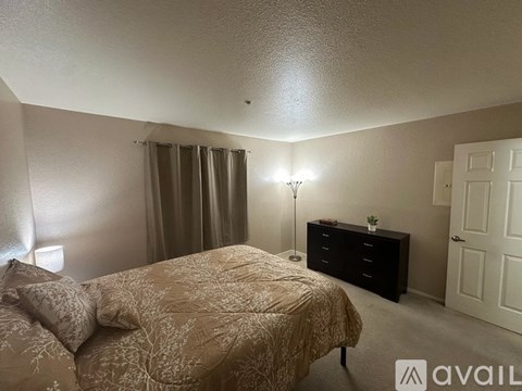 A bedroom with a bed, nightstand, and lamp.