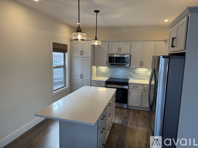 A kitchen with a white countertop and stainless steel appliances.