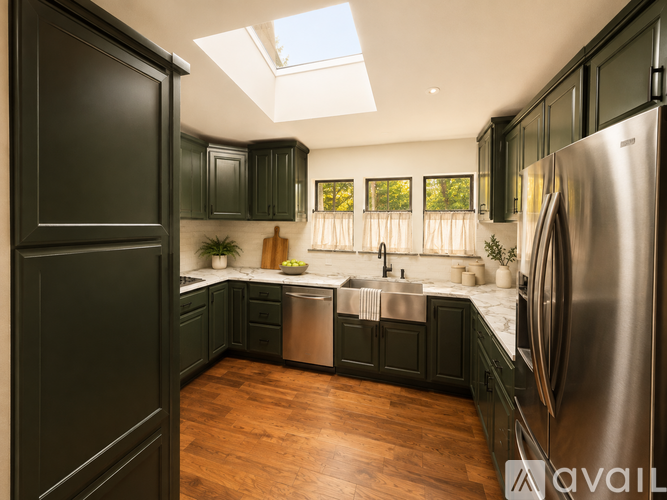 A kitchen with black cabinets and a stainless steel refrigerator.