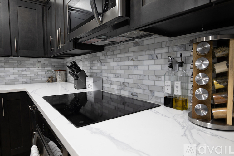 A kitchen with a black stove top oven and a white counter top.