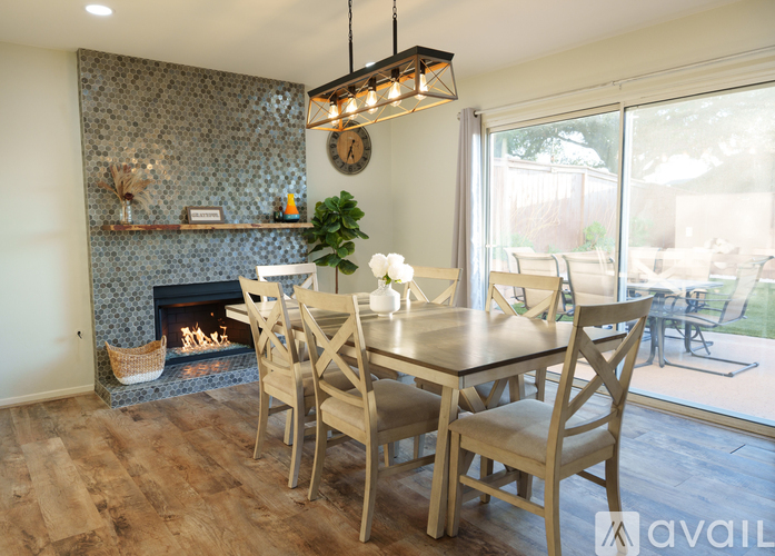 A dining room with a fireplace and a table set for four.