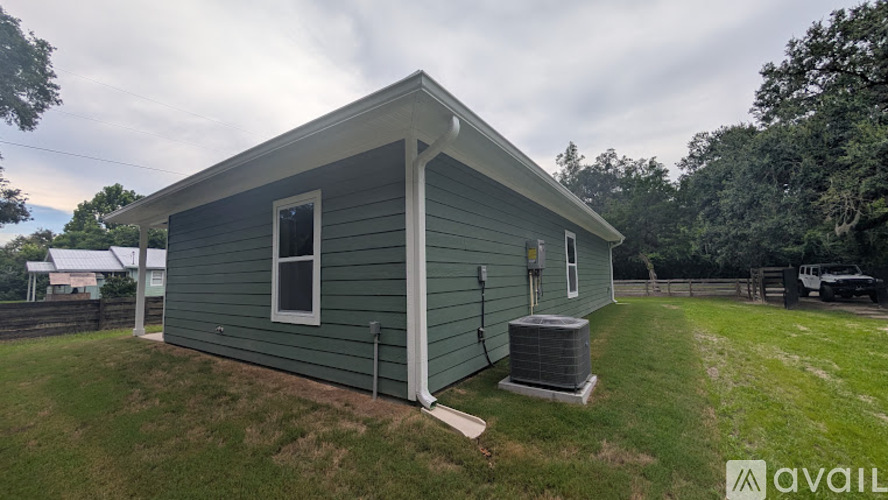 A small house with a green siding is available for rent.