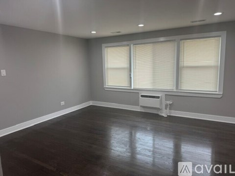 A room with wooden floors and grey walls.