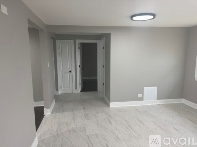 A room with a wooden floor and a white door.