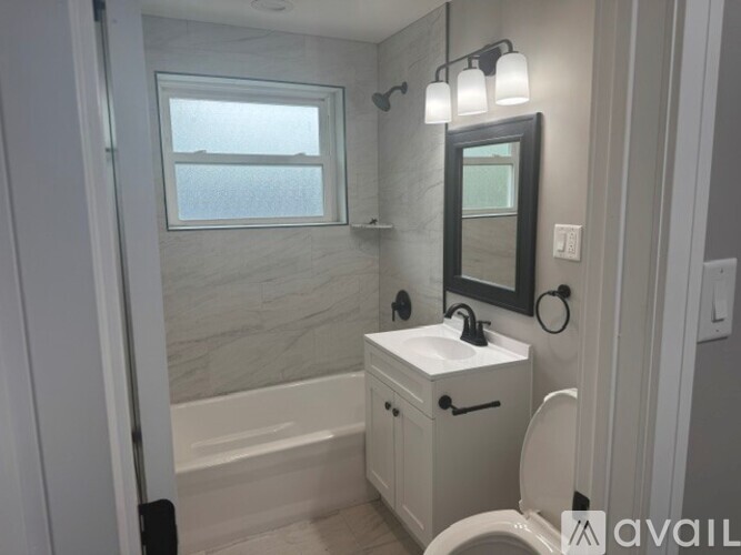 A bathroom with a white toilet, sink, and a mirror.