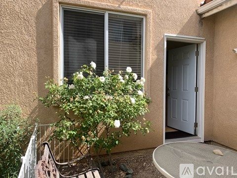 A house with a grey door and a window with white blinds.