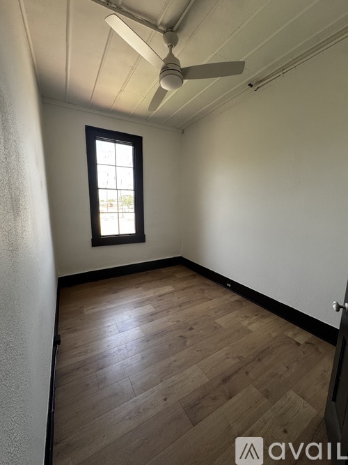 A room with wooden flooring and a ceiling fan.