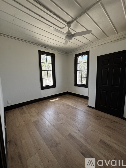 A room with wooden floors and a ceiling fan.