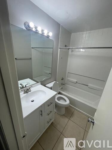 A bathroom with a sink, toilet, and a mirror.