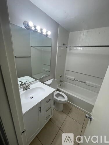 A bathroom with a sink, toilet, and a mirror.