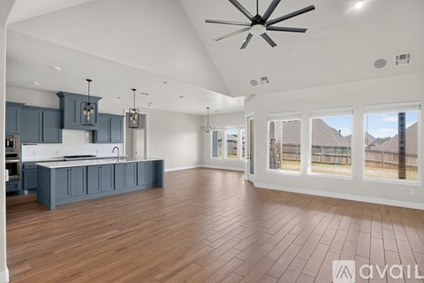 A spacious kitchen with dark blue cabinets and a white countertop.