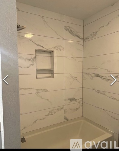 A bathroom with marble tiles and a shower.