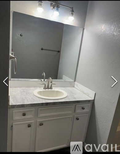 A bathroom with a white sink and a mirror.
