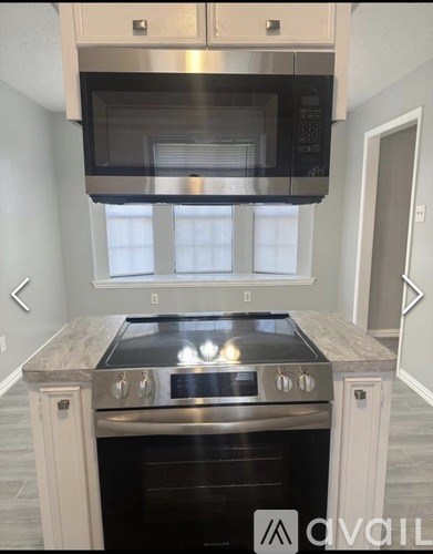 A modern kitchen with a stainless steel oven and microwave.