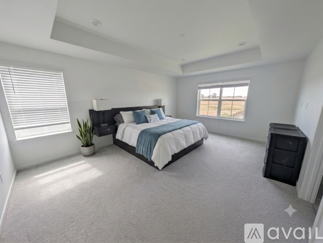 A bedroom with a large bed and a window with blinds.