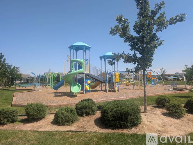 A playground with a green slide and a blue tower.