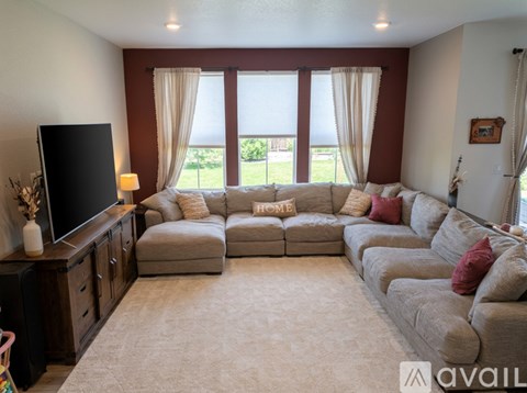 A living room with a large sectional sofa and a flat screen TV.