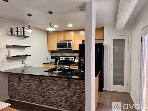 A kitchen with a black stove top oven and a black refrigerator.