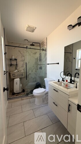 A bathroom with a toilet, sink, and shower.