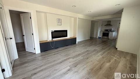 A spacious living room with a television and hardwood flooring.