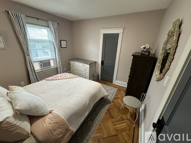 A bedroom with a bed, dresser, and mirror.