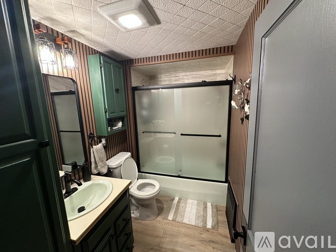 A bathroom with a toilet, sink, and shower.