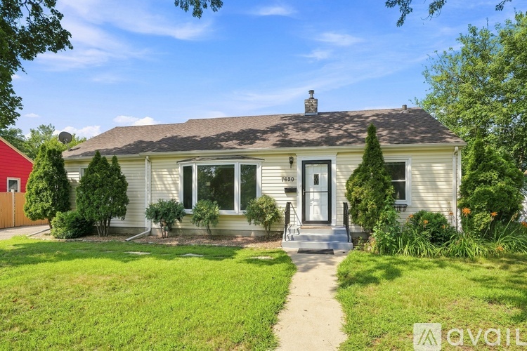 A house with a front yard and a pathway leading to the front door.
