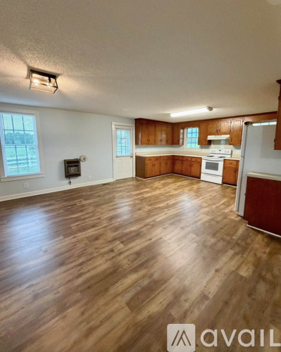 A kitchen with wooden floors and white walls.